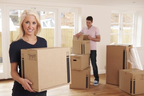 Movers carrying household furniture through a London property entrance