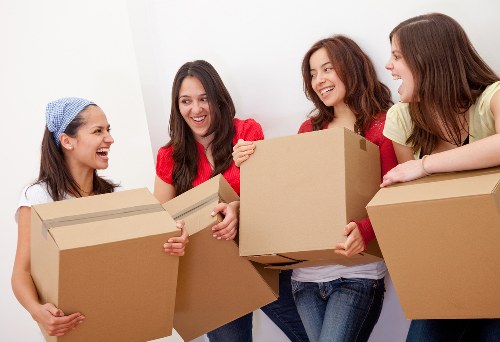 Removal team handling boxes and furniture in a London residential move